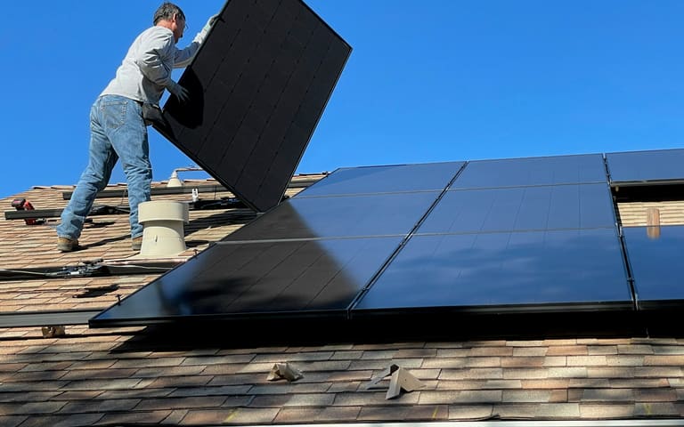 Técnico realizando a manutenção de painéis solares
