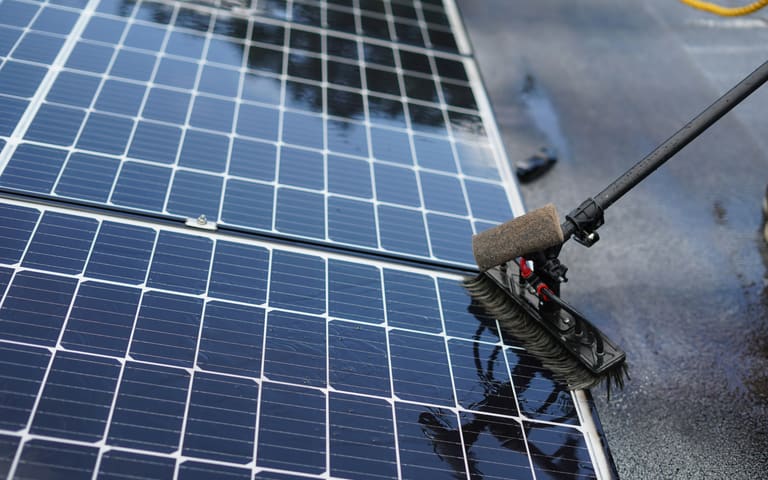 Técnico limpando painéis solares